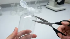 Stříhání plastové lahvičky nůžkami v laboratorním prostředí