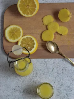 Dřevěné prkénko s nakrájenými citrony a sklenicí šťávy